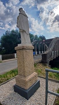 socha Jána Nepomuckého stojí pred mostom po pravej strane