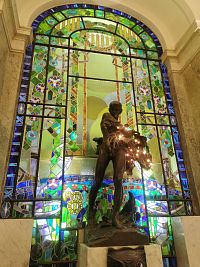 chlapec s kvetinami a vitráž za bazénikom