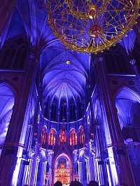 v popredí luster, vzadu osvietený hlavný oltár a okná