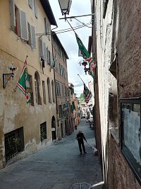 bočná ulička so zástavami kontrády Oca (hus)