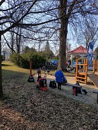 účastníci turnaja práve obedujú pri hudobnom pavilóne z roku 1927