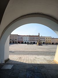 pohľad na štvorcové Masarykovo námestie s morovým stĺpom, za ktorým sa nachádza fontánka s tancujúcimi sedliakmi