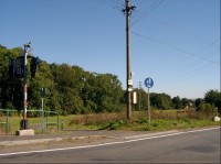 Ze západu: Pohled na rozcestník ze zeleně značené cesty na západ (přez Vlčinec do Nové Role).