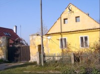Dům se štítem a dřevěnou branou: východ obce