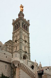 Marseille -  Zlacená socha Panenky Marie s děťátkem, korunující zvonici Notre-dame de la Garde