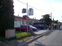Restaurace: Pohled na restauraci v obci, vlevo informační tabule