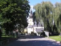 Štáblovice: Pohled na obec, vpravo autobusová zastávka, vlevo zámecká zahrada, v pozadí kostel