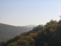 pohled od brány hradu Hukvaldy, Bačův kopec v pozadí uprostřed-zoom