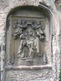 Relief: Kamenný relief Panny Marie Staroboleslavské zasazený do hřbitovní zdi