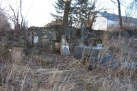 Poničený hřbitov za kostelem