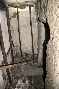 Horní patro bunkru, vstupní chodba, pohled ze strany vstupního poklopu. Vpravo je vidět vchod do hlavní místnosti bunkru.