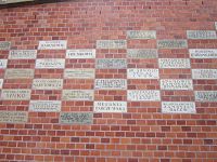 Krakov, na hradbách umístěná jména dárců, díky nimž proběhla oprava hradu Wawelu