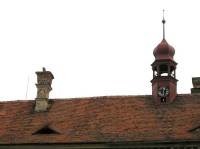 Typická věžička a pověstmi opředená hlava na komíně ratajského zámku