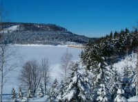 Fláje v zimě: Pohled na hráz a zasněženou přehradu