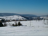 Ze Strážného vrchu 5: Pohled do hraničního údolí Svídnice, nad nějž vystupují Růžový vrch s rozhlednou a Kamenný vrch (uprostřed)