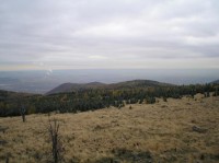 Panoramatický výhled na jih: Na Žatecko přes trojici vrchů zleva Jánský vrch, Jezeří a Homolka.