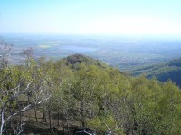 ze skály: vodní nádrže Kyjice a Zaječice, na úpatí hor Vysoká Pec a Jirkov, na obzoru Žatecko, v popředí skalnatý vrchol Jezeří