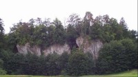 Holštejn: Pohled na skalní masív,místo zříceniny hradu Holštejna.Dole za porostem leží jeskyně Lidomorna.