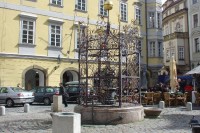 Malé náměstí: Kašna s ozdobnou mříží - Staré Město, Malé náměstí; znamenitá ručně kovaná renesanční mříž s datem 1560. V 17. st. doplněna zlaceným českým lvem nad velkou makovicí. 